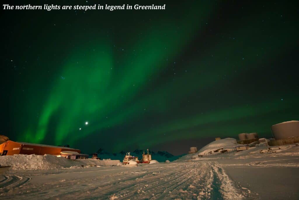 Northern lights above the now and buildings of Tasiilaq in Greenland 