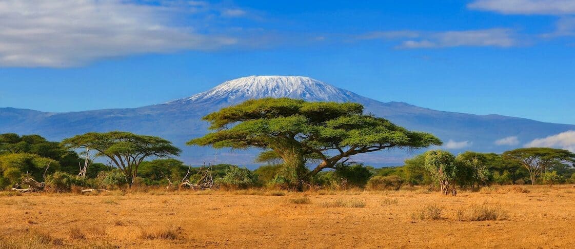 Kilimanjaro mountain Tanzania snow capped under cloudy blue skies captured whist on safari in Africa Kenya - gorilla tracking in uganda